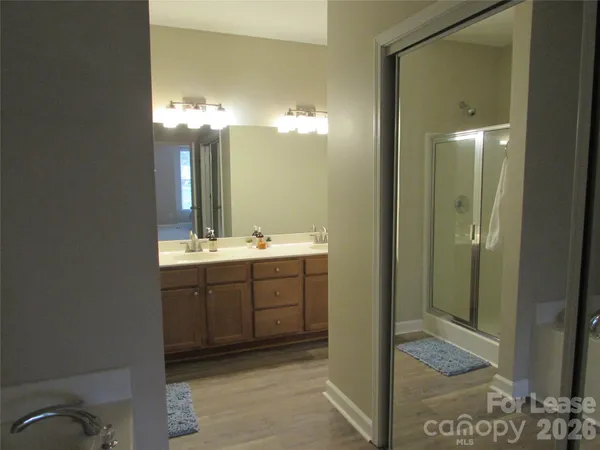 a bathroom with a sink shower and a mirror