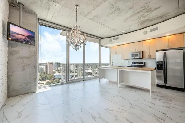 a kitchen with granite countertop a refrigerator and white cabinets