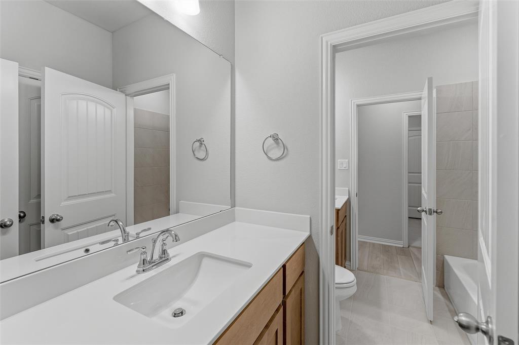 1237 Frio Drive Springtown, TX 76082 - Photo 13 of 25 Bathroom vanity featuring a single integrated sink, chrome faucet, and expansive mirror