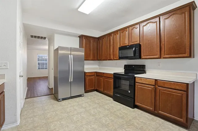 a kitchen with stainless steel appliances granite countertop a refrigerator stove and microwave