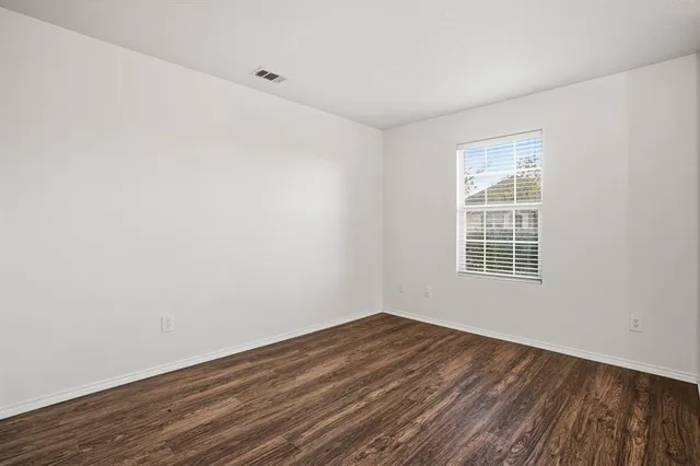 a view of a room with wooden floor and windows