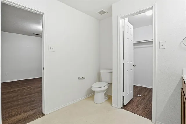 a bathroom with a granite countertop toilet and a sink