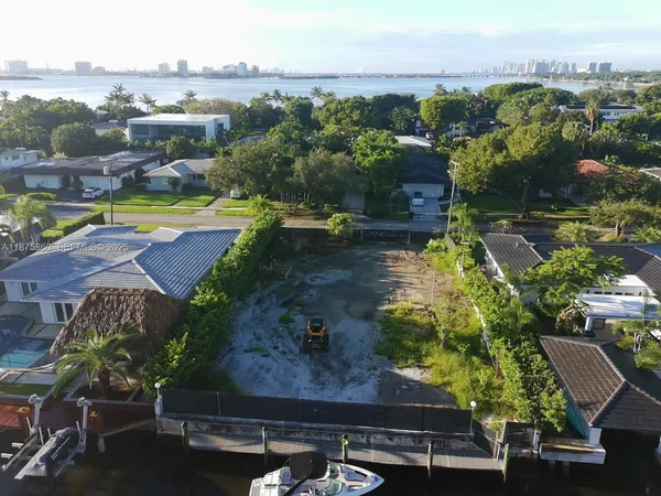 an aerial view of residential houses with outdoor space and lake view