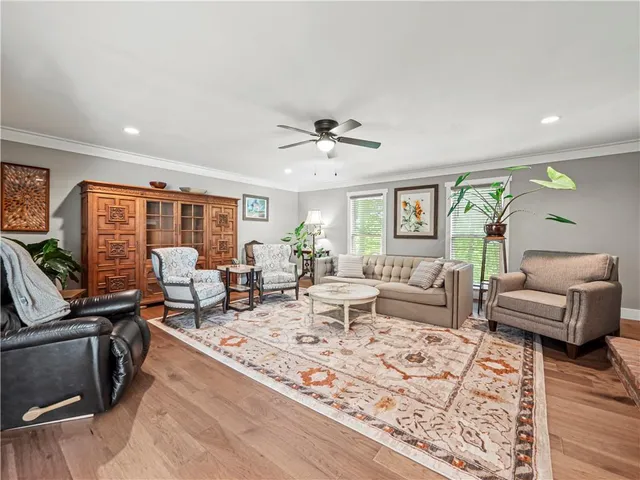 a living room with furniture ceiling fan and a rug