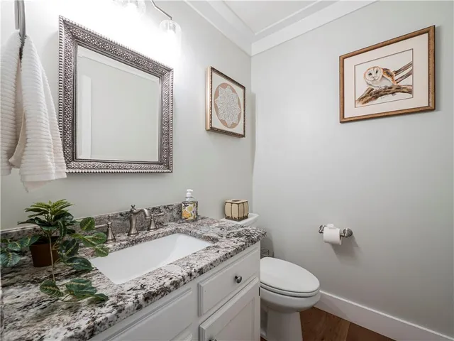 a bathroom with a granite countertop sink and a toilet