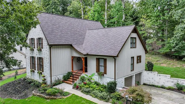 a house view with a garden and large trees