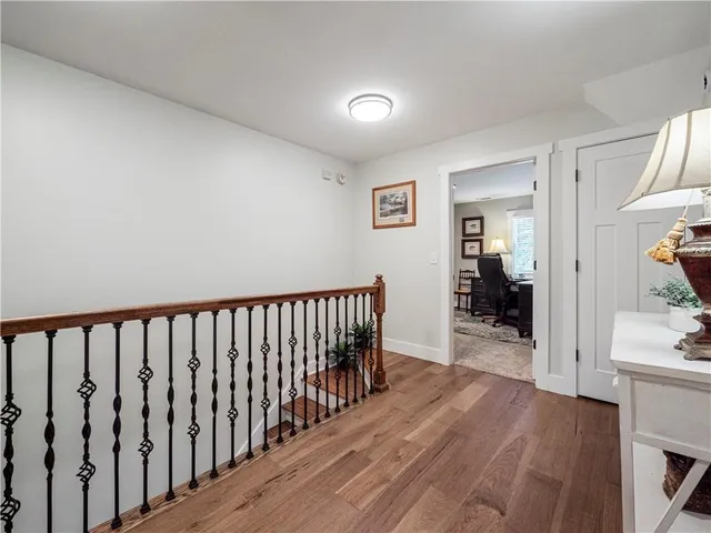 a view of a hallway with wooden floor and a living room