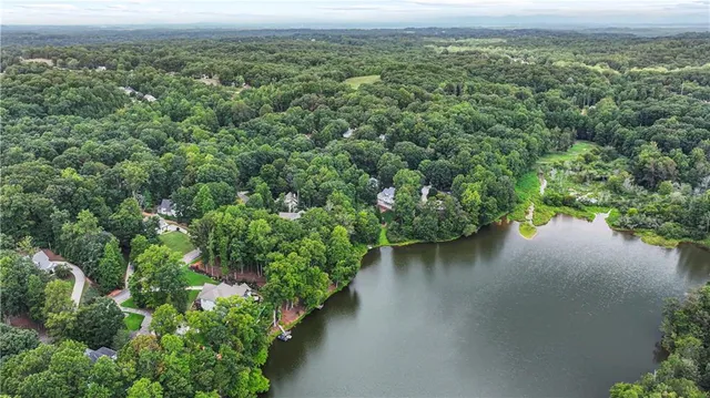 an aerial view of a house with a yard and lake view