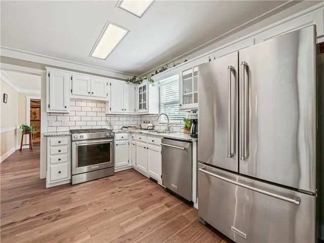 a kitchen with stainless steel appliances a refrigerator sink and cabinets