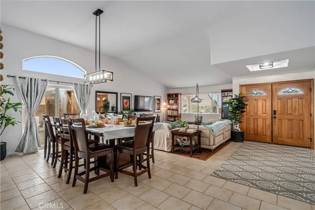 a view of a dining room and livingroom with furniture a chandelier and wooden floor