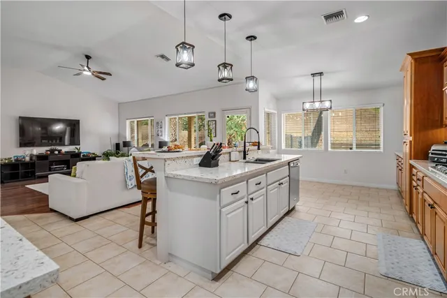 a large white kitchen with a large window and stainless steel appliances