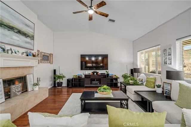 a living room with furniture a fireplace and a flat screen tv