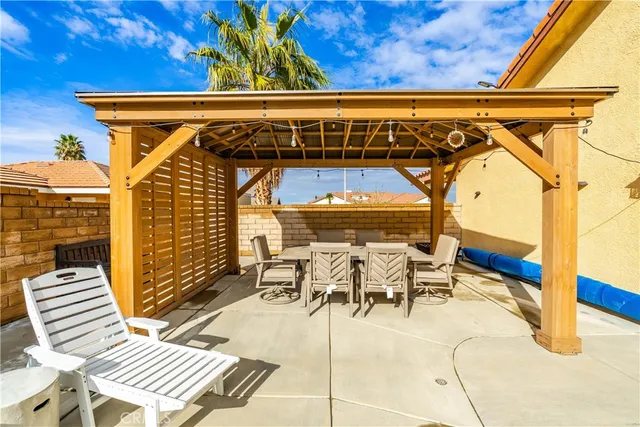 a view of a patio with table and chairs with wooden floor and fence