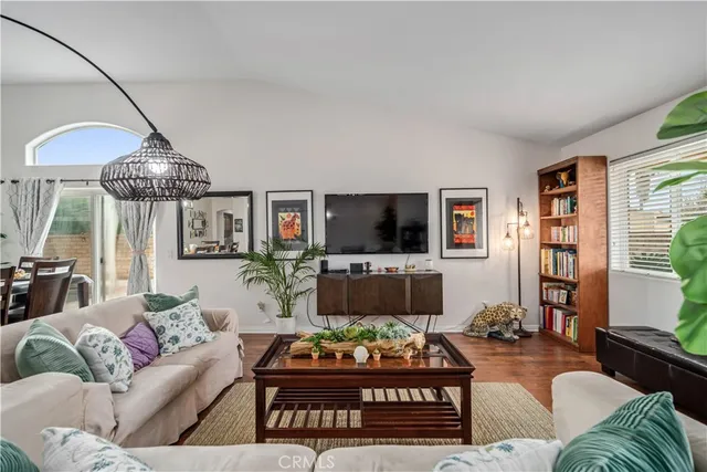 a living room with furniture a flat screen tv and a large window