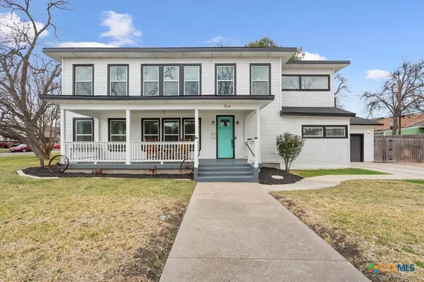 a front view of a house with swimming pool and glass windows