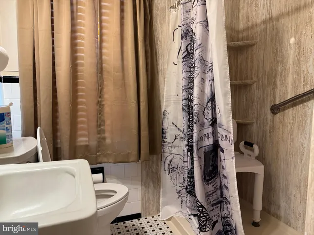 a bathroom with a toilet and shower curtain