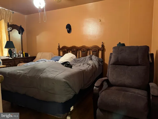 a bed sitting in a bedroom next to a window and a lamp