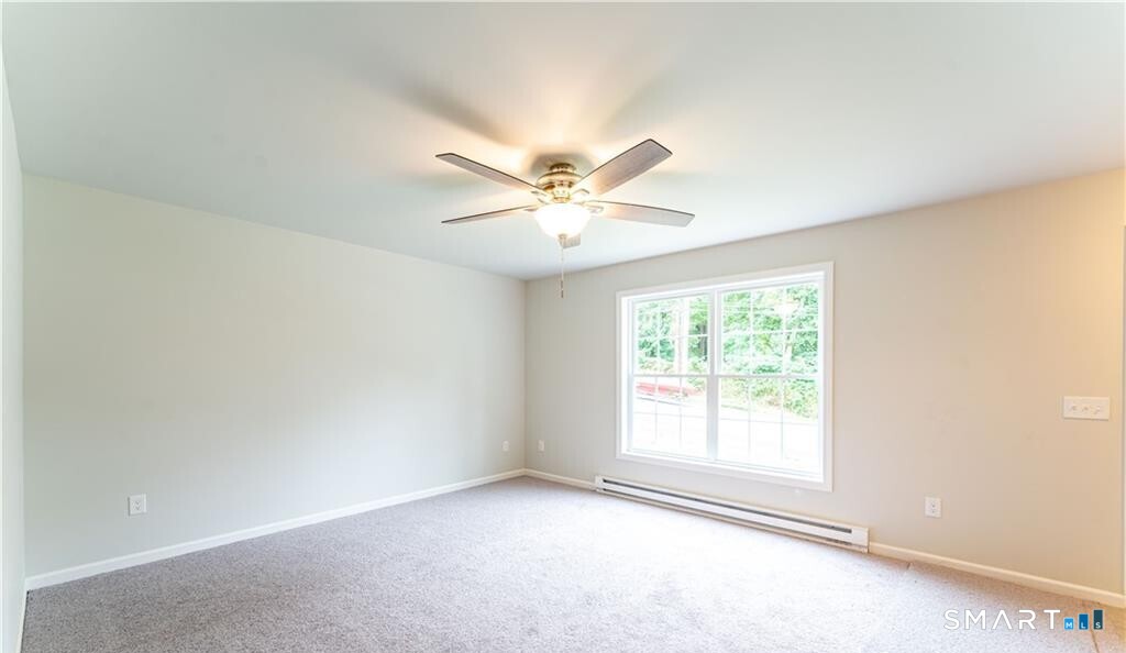 152 Grove Avenue, Unit B Groton, CT 06340 - Photo 13 of 17 an empty room with windows and ceiling fan