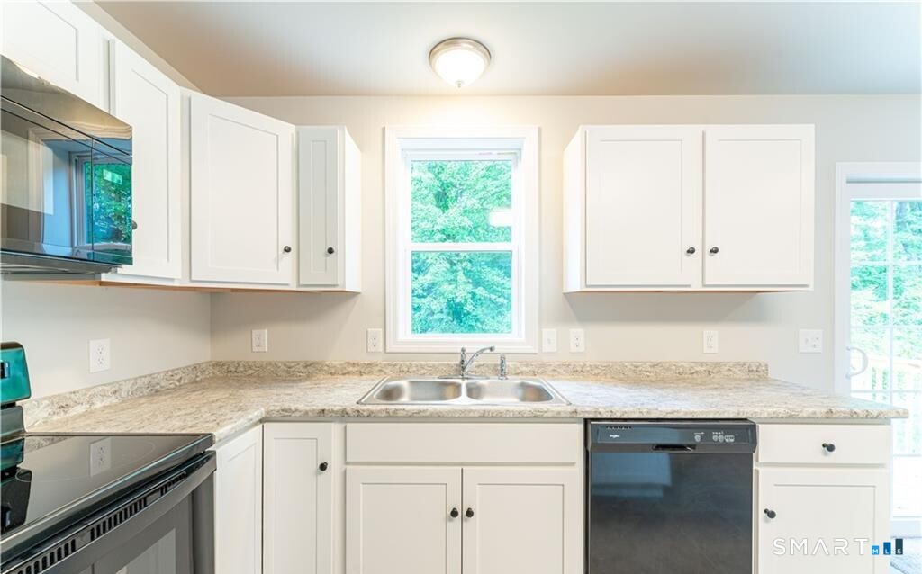 152 Grove Avenue, Unit B Groton, CT 06340 - Photo 6 of 17 a kitchen with granite countertop white cabinets and a window