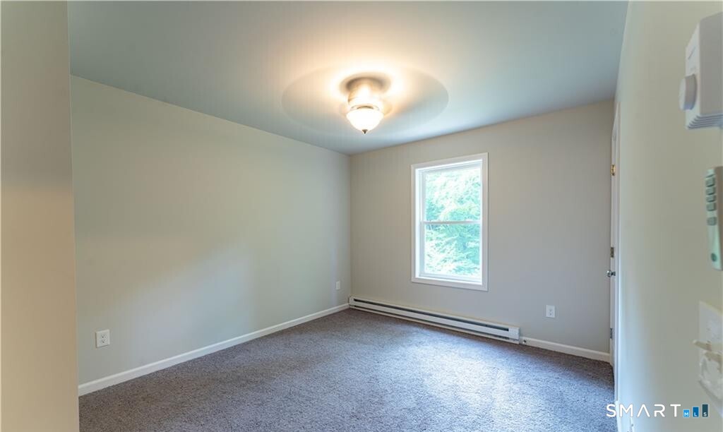 152 Grove Avenue, Unit B Groton, CT 06340 - Photo 7 of 17 an empty room with a window and a ceiling fan