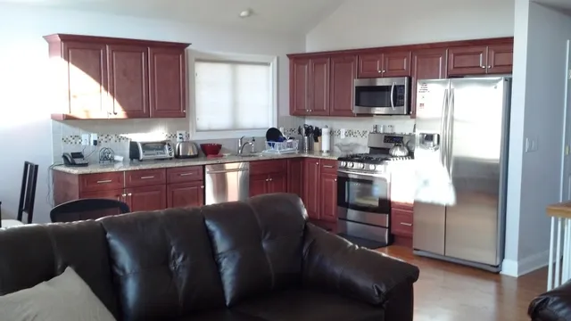 a kitchen with stainless steel appliances granite countertop a refrigerator stove top oven a sink and dishwasher