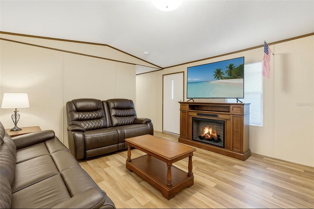 327 Tindel Camp Road Lake Wales, FL 33898 - Photo 2 of 10 a living room with furniture a flat screen tv and a fireplace