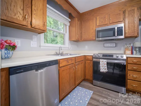 a kitchen with stainless steel appliances granite countertop a sink a stove a microwave and cabinets