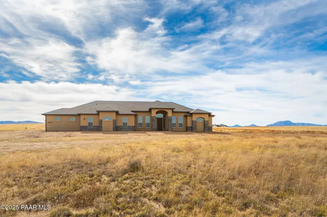 a view of a large house with a big yard and large trees