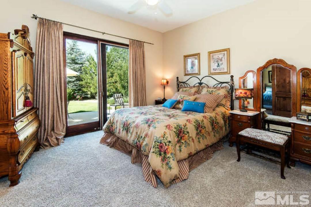 12760 Silver Wolf Road Reno, NV 89511 - Photo 12 of 25 a spacious bedroom with a bed and a flat tv screen on dresser