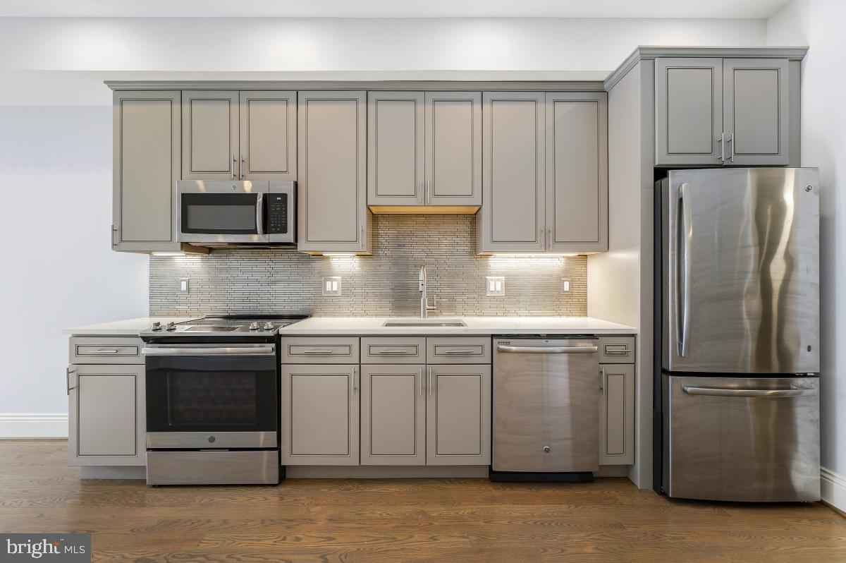 416 A Street Southeast, Unit 1 Washington, DC 20003 - Photo 13 of 30 a kitchen with granite countertop a refrigerator stove and microwave