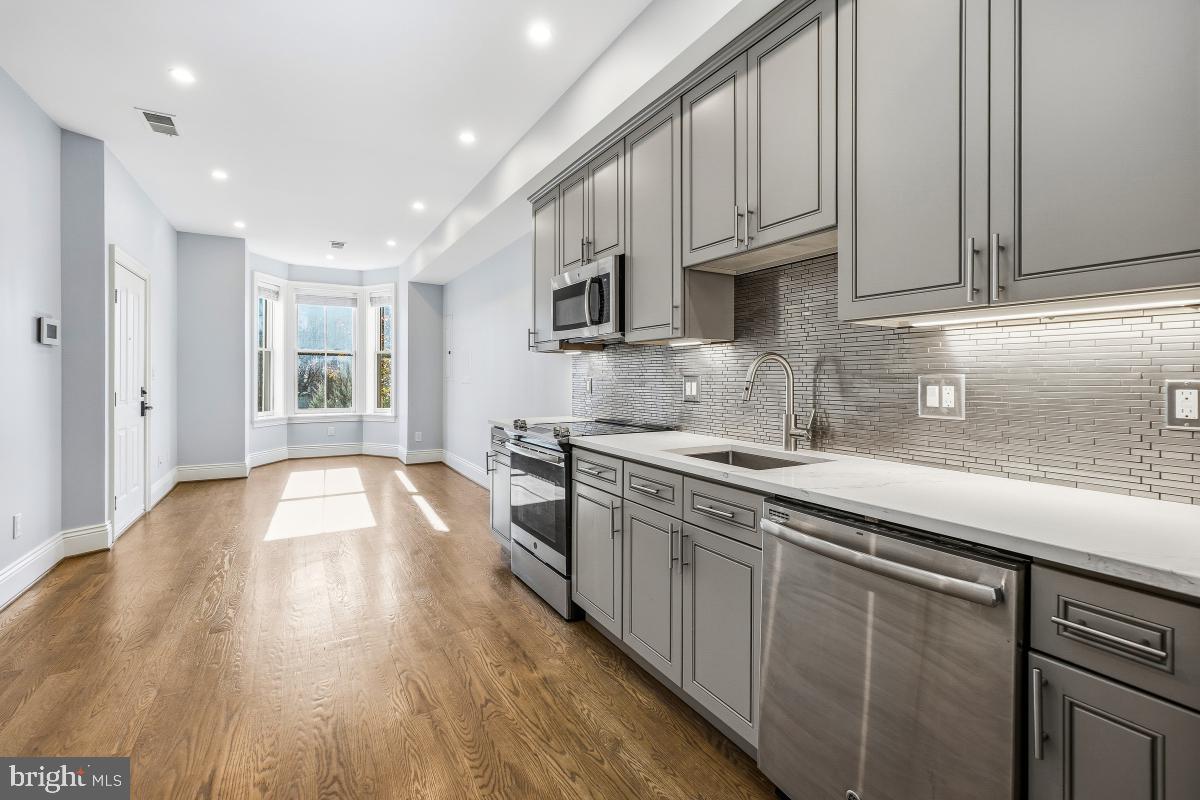 416 A Street Southeast, Unit 1 Washington, DC 20003 - Photo 16 of 30 a kitchen with stainless steel appliances granite countertop white cabinets a sink and dishwasher