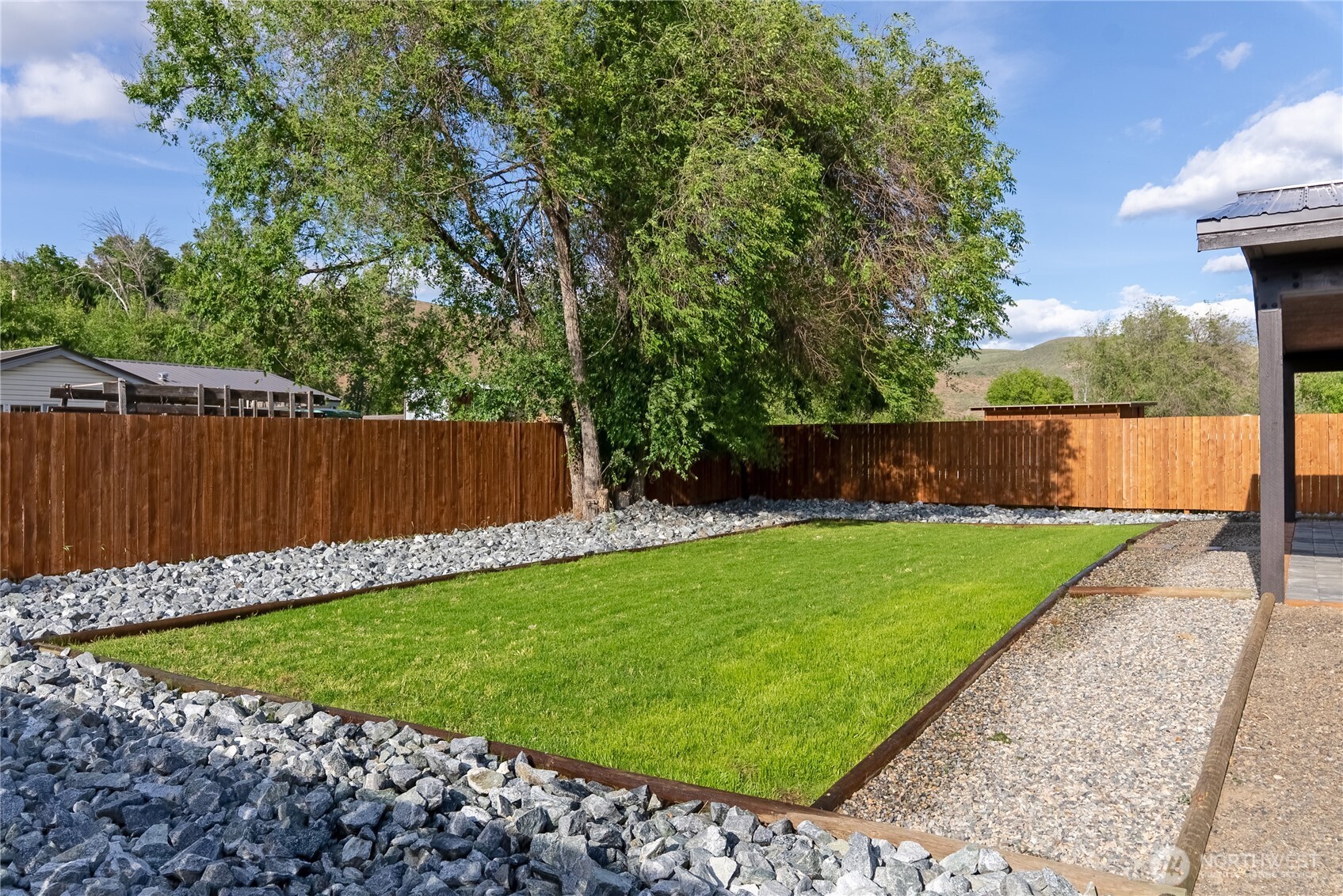 1110 Riverside Avenue Twisp, WA 98856 - Photo 6 of 28 a view of a backyard with a small pool and wooden fence