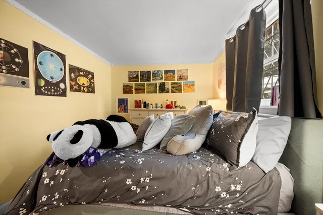 a bed sitting in a bedroom next to a window