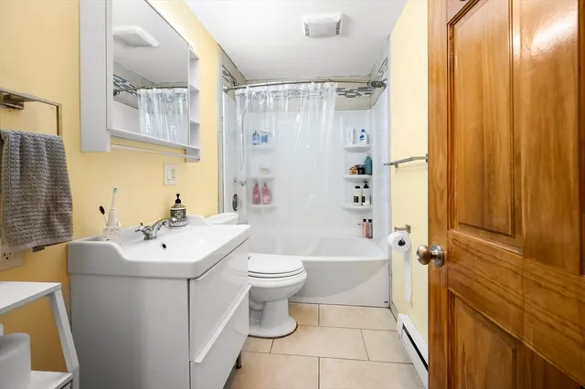 a bathroom with a sink a toilet and shower curtain