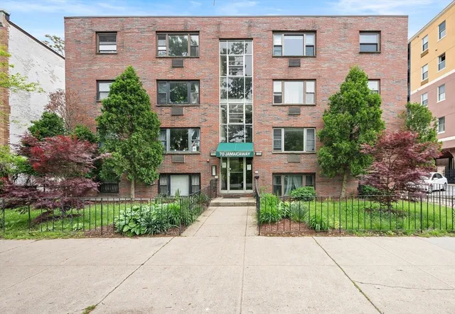 front view of a brick house with a yard