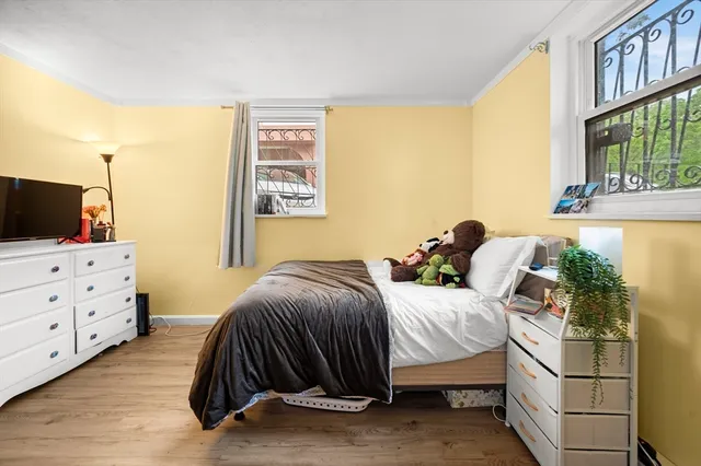 a bedroom with a bed and a flat tv screen on dresser
