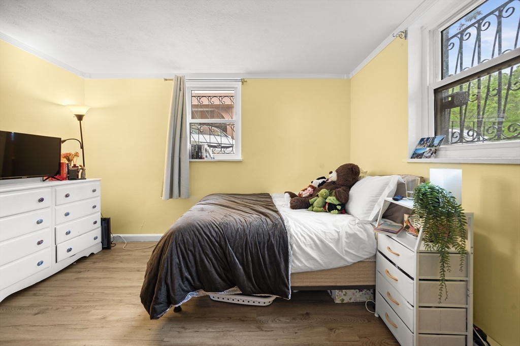 70 Jamaicaway, Unit 1 Boston, MA 02130 - Photo 10 of 19 a bedroom with a bed and a flat tv screen on dresser