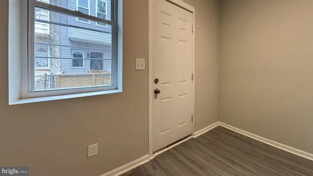 a view of a small space with wooden floor and a window