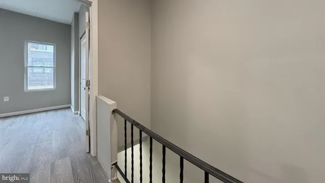a view of a hallway with wooden floor and staircase