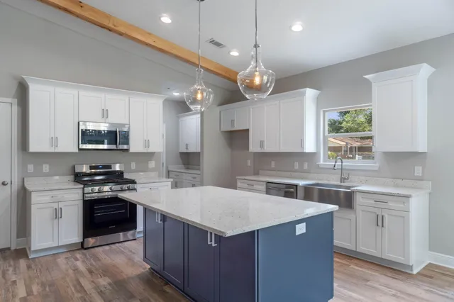 a kitchen with a stove sink and cabinets