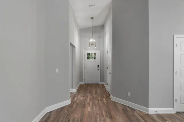 a view of a room with wooden floor and a bathroom
