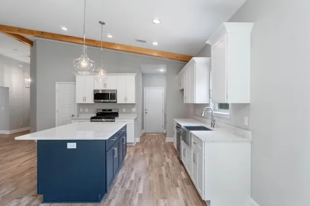 a kitchen with stainless steel appliances a sink stove and cabinets