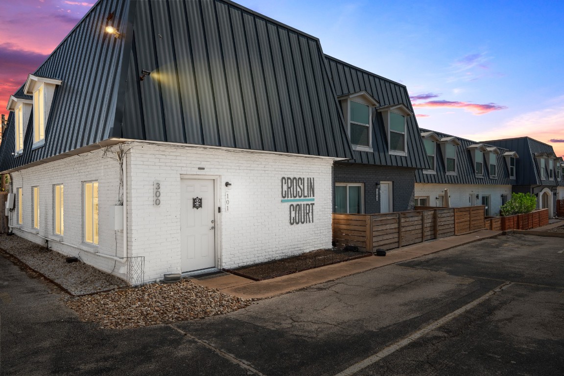 View of front of home featuring mansard roof, brick siding, and a residential view