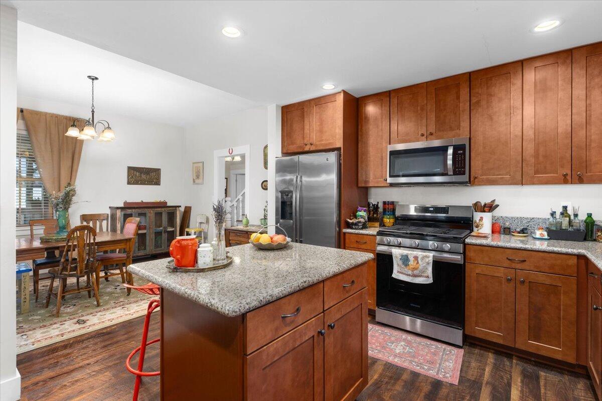 24894 Long Street Fall River Mills, CA 96028 - Photo 12 of 43 a kitchen with stainless steel appliances granite countertop a stove top oven a sink dishwasher a dining table and chairs with wooden floor