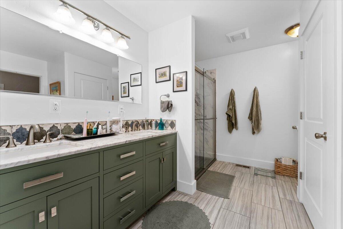 24894 Long Street Fall River Mills, CA 96028 - Photo 25 of 43 a spacious bathroom with a double vanity sink and a mirror