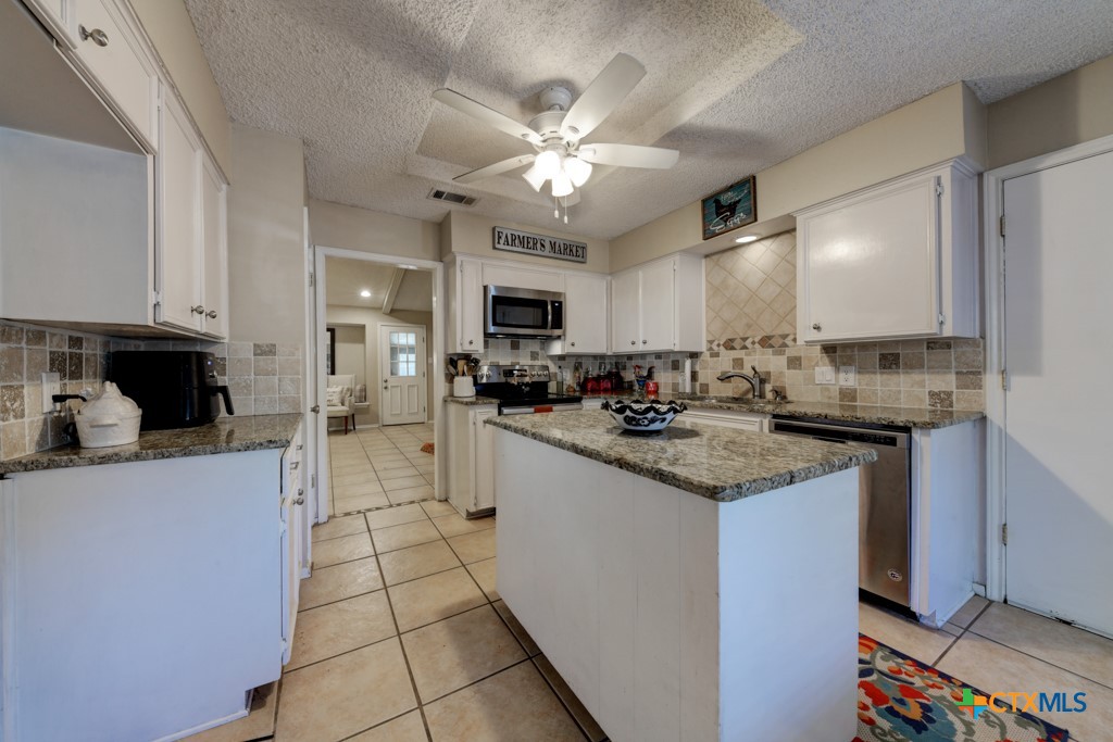 1229 Rapids Road New Braunfels, TX 78130 - Photo 9 of 27 a kitchen with stainless steel appliances granite countertop a sink and cabinets