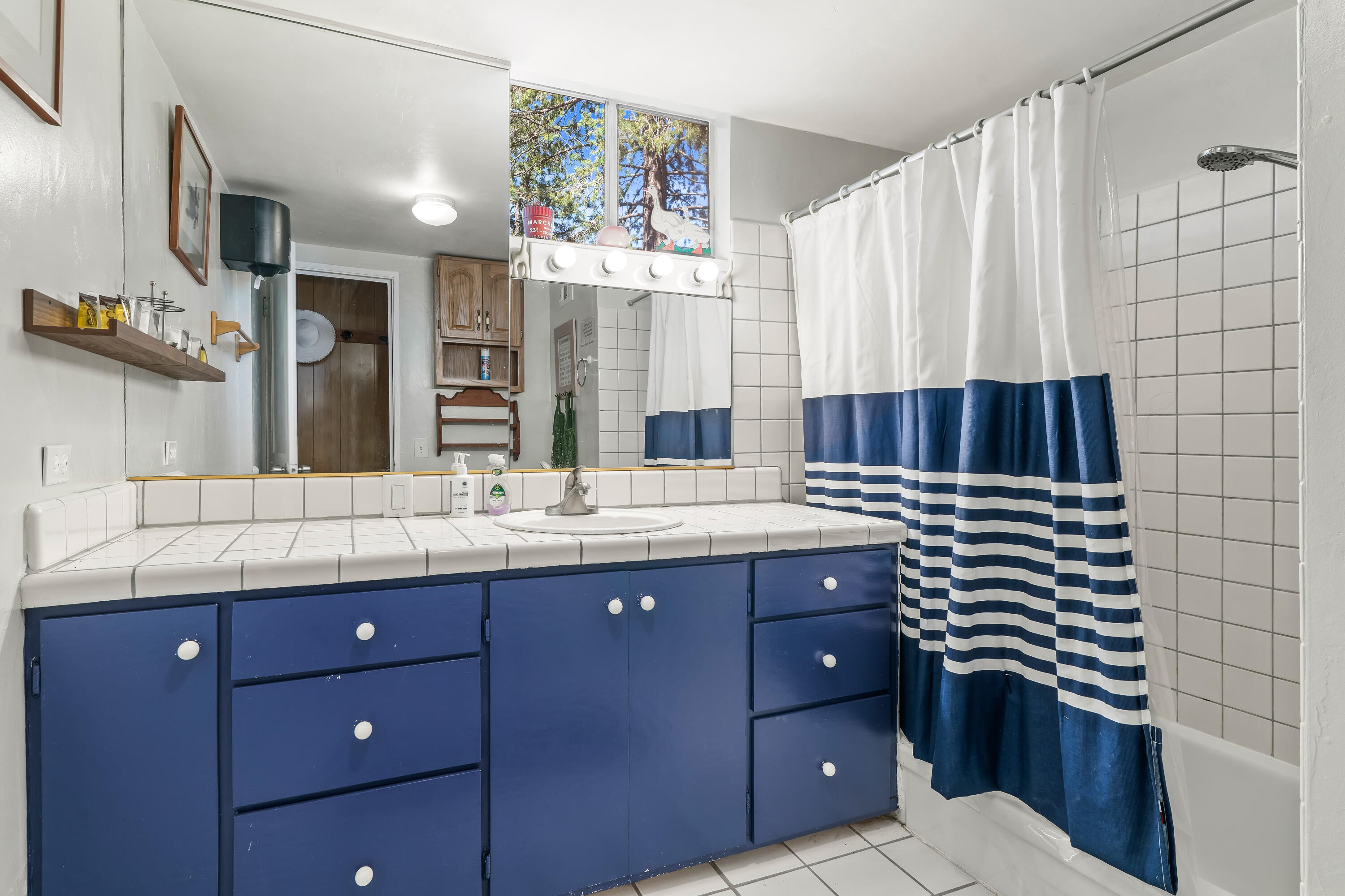 23061 Banning Idyllwild Road Idyllwild, CA 92549 - Photo 32 of 46 a bathroom with a granite countertop sink vanity and mirror