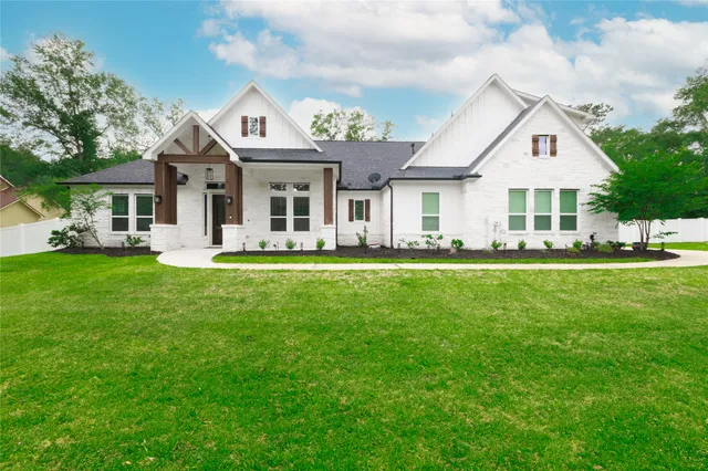 a front view of a house with a garden and trees