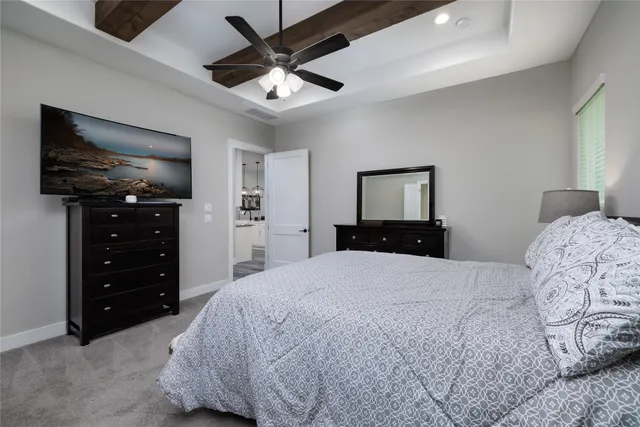 a spacious bedroom with a bed and a chandelier