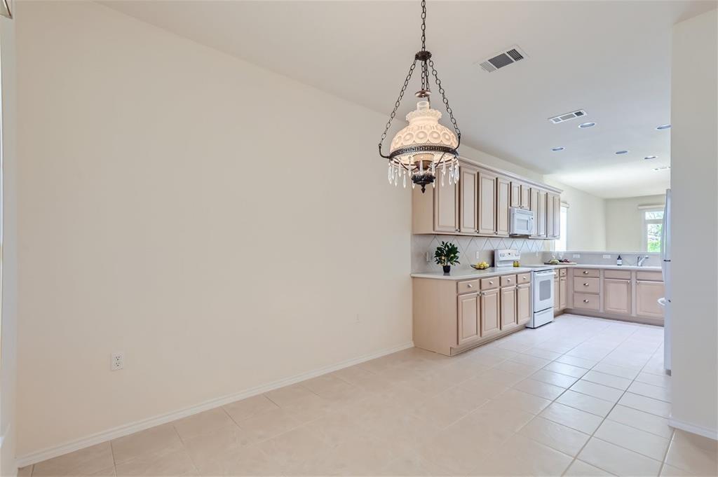 212 Summer Road Georgetown, TX 78633 - Photo 11 of 18 a room with stainless steel appliances a white cabinets and a wooden floor